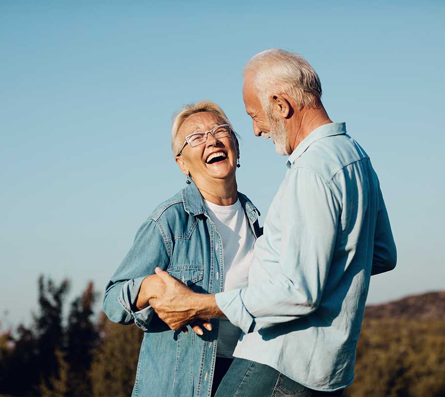 Senior husband and wife holding hands and smiling