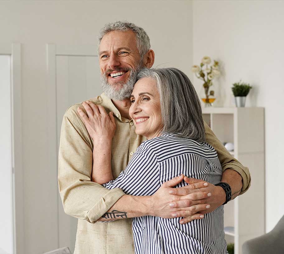 Senior husband and wife hugging and smiling